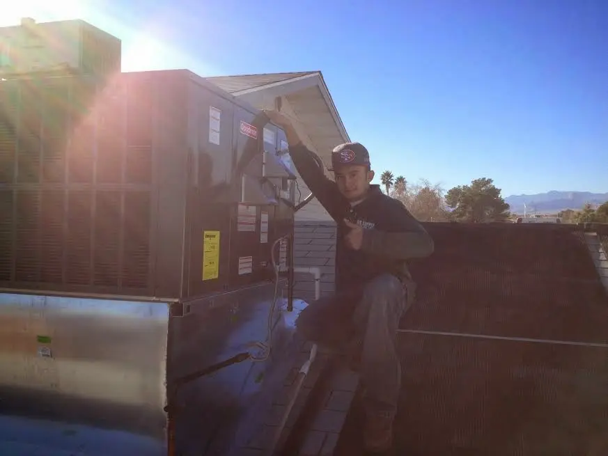 HVAC technician performing Heat Pump Repair on a rooftop unit in Forestville